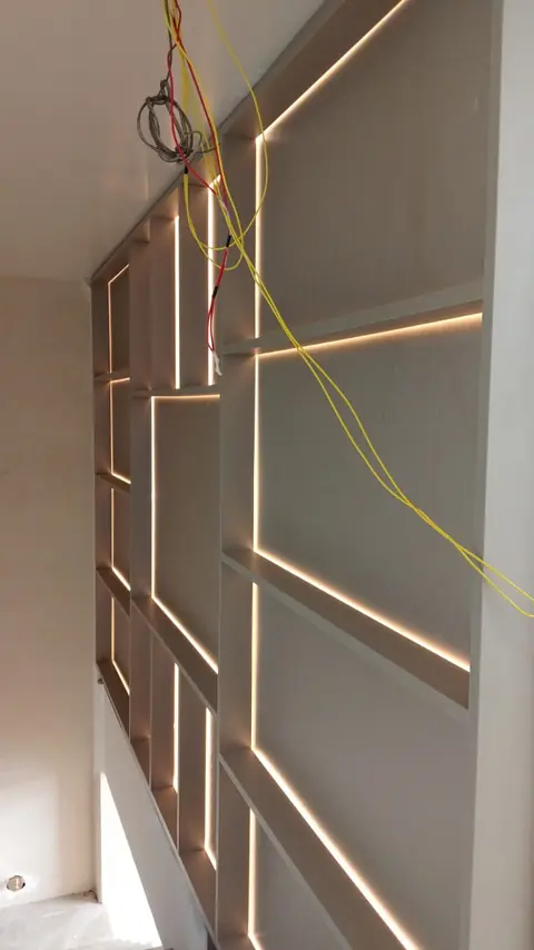 Painel de parede em montagem, com fitas de LED e fiação aparente