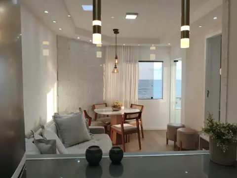 Sala de estar e jantar com luminárias pendentes e forro de gesso com spots